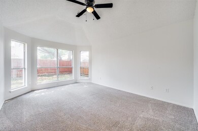 Carpeted spare room featuring ceiling fan and a te