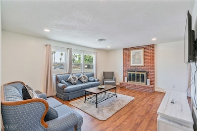 Living room with a textured ceiling, a fireplace,