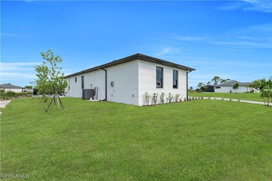 Rear view of house featuring a lawn and stucco sid