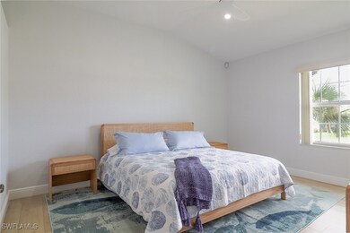 Bedroom featuring lofted ceiling, light wood-type