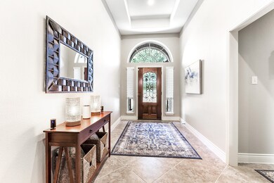 Another perspective of this welcoming entry area, accommodating tables and seating. To the right, there is a hallway leading to two guest bedrooms that share a bathroom adjacent to them.