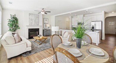 Living room with wood finished floors, ceiling fan, a glass covered fireplace, and recessed lighting