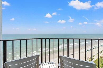 Balcony featuring view of water and beach