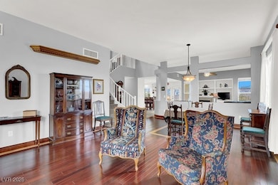 Living room with visible vents, stairway, baseboar