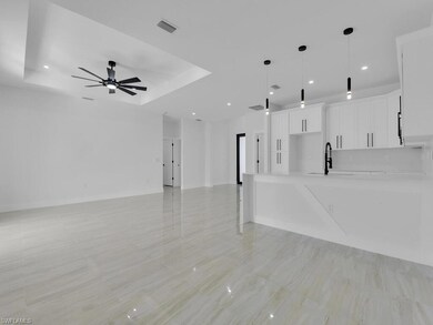 Unfurnished living room featuring ceiling fan, a r