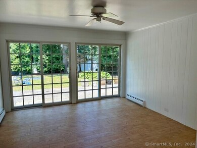 Sun room with double sliding glass doors leading out to the stone patio and beautifully landscaped, fenced in backyard