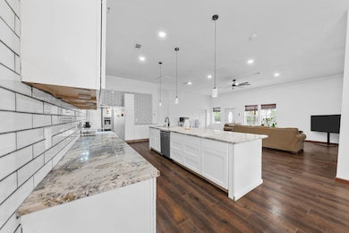 Kitchen with a ceiling fan, light stone counters, 