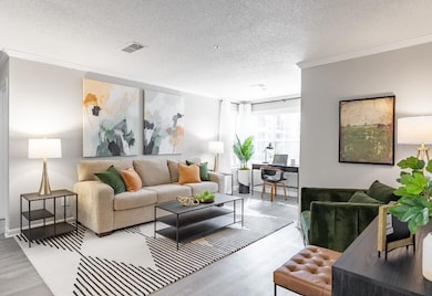 Living room with ornamental molding, hardwood / wood-style floors, and a textured ceiling