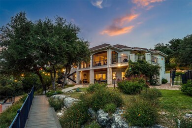 Back of property at dusk featuring a balcony, sta