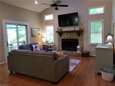 The Living Room lets the light in with transom windows, skylights, and rear sliding doors that leads to the deck. There is also the wood burning fireplace  with the stone surround that becomes a focal point