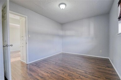 Empty room featuring a textured ceiling and dark w