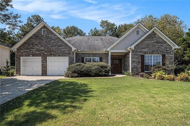 Single story home with a front lawn, concrete driveway, brick siding, and an attached garage