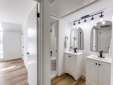 Bathroom with two vanities, wood finished floors,