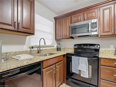 Kitchen with light stone counters, sink, and black