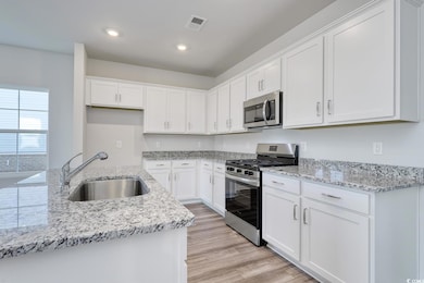 Kitchen with stainless steel appliances, a sink, w
