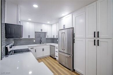 Kitchen with light wood finished floors, light cou