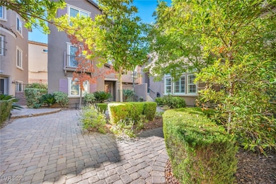 A peaceful, tree-lined courtyard welcomes you home with mature landscaping, trimmed hedges, and charming stone pavers that set the tone for this inviting community.