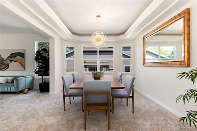 Spacious dining room with tray ceiling and modern lighting.