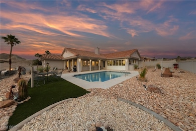 Pool at dusk featuring a fenced backyard, a patio,