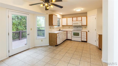 Kitchen featuring white appliances, light countertops, light tile patterned floors, and ceiling fan