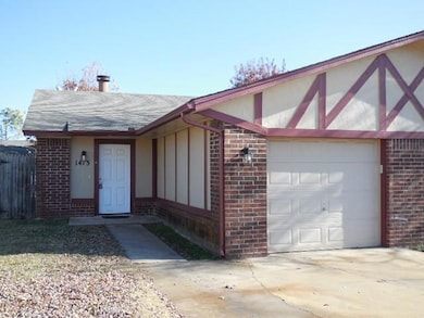 View of front of property with brick siding, a gar
