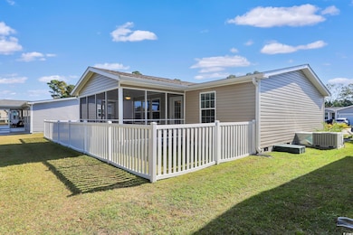 Back of house featuring a sunroom and a yard