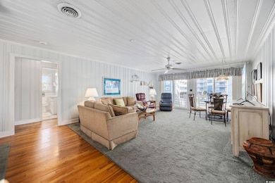 Living room with baseboards, visible vents, wood f