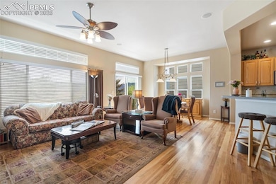 Living area with a ceiling fan, light wood-type flooring, and recessed lighting