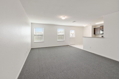 Unfurnished room featuring light carpet and baseboards