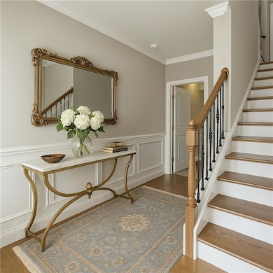 Foyer entrance featuring a decorative wall, crown 