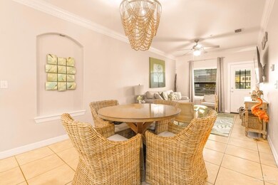 Dining room with baseboards, visible vents, light tile patterned flooring, crown molding, and ceiling fan with notable chandelier