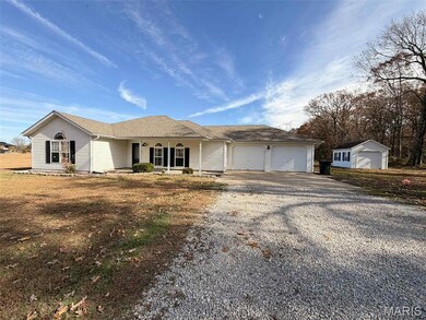 Ranch-style home featuring driveway, covered porch, roof with shingles, and an outbuilding