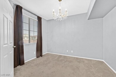 Carpeted spare room featuring a chandelier and bas