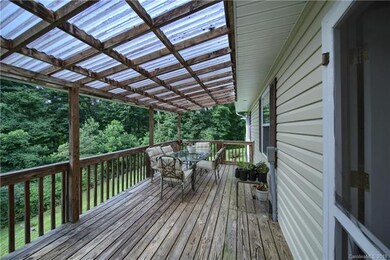 Covered back deck looks over gently sloping back y