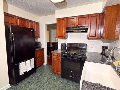 Kitchen featuring a textured ceiling, black applia