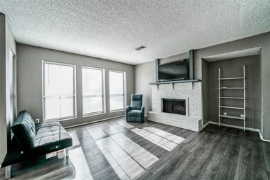 A brick accented fireplace crowned with a wooden m