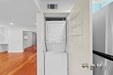 Laundry area with hardwood / wood-style floors and