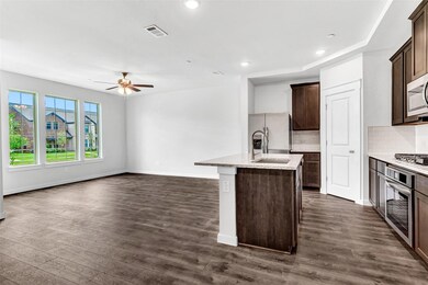 Kitchen with stainless steel appliances, a center island with sink, tasteful backsplash, and dark hardwood / wood-style floors