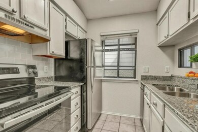 Kitchen featuring stainless steel electric range, healthy amount of natural light, under cabinet range hood, backsplash, and a textured wall
