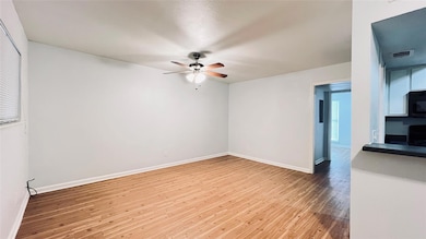 Unfurnished room featuring a ceiling fan and wood
