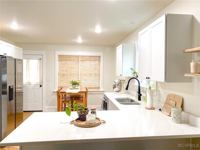 Kitchen with light countertops, white cabinetry, a