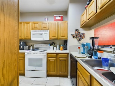 Kitchen with light tile patterned floors, white a