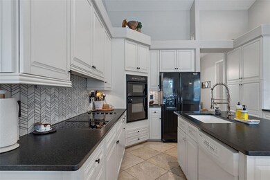 Newly remodeled kitchen with Black stone counter tops & farmhouse sink. Kitchen has wine fridge, beverage fridge and eat up breakfast bar