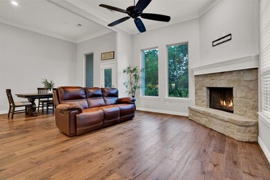 Living room with a stone fireplace, hardwood / woo