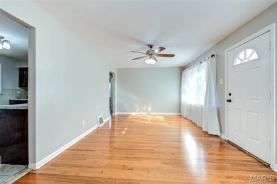 Kitchen entrance with light wood finished floors and a ceiling fan