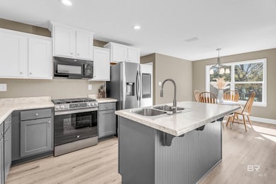 Kitchen with gray cabinetry, appliances with stainless steel finishes, light countertops, light wood-style floors, and recessed lighting