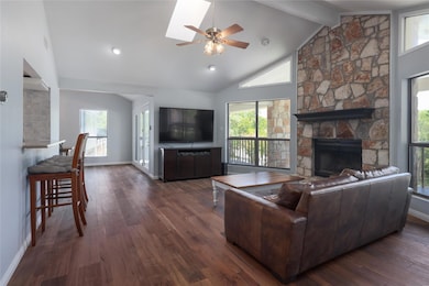 Living area with a ceiling fan, a fireplace, dark
