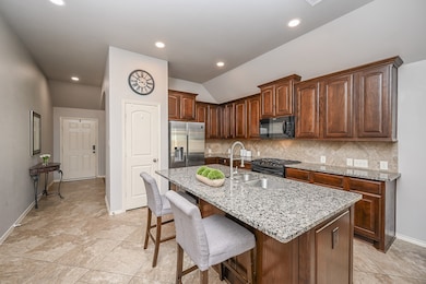 This kitchen features sleek granite countertops, r