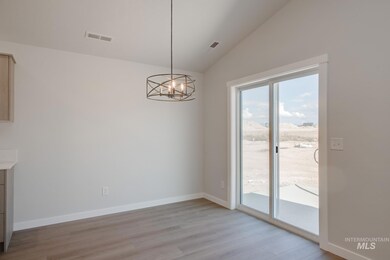 Unfurnished dining area featuring vaulted ceiling, a chandelier, and light wood finished floors