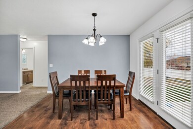 Dining area with dark wood-style floors and a chandelier